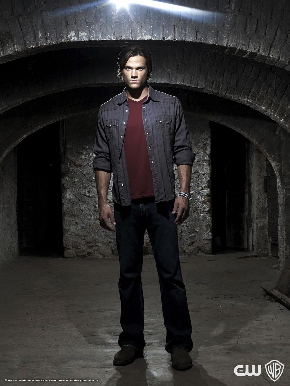 Promo picture for season 4. Tall man with brown hair wearing jeans and a red undershirt beneath an unbuttoned work shirt with the sleeves rolled up. He's staring into the camera looking dark and mysterious.