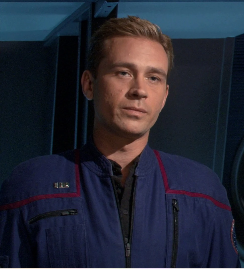 Attractive blond man in a jumpsuit Starfleet uniform