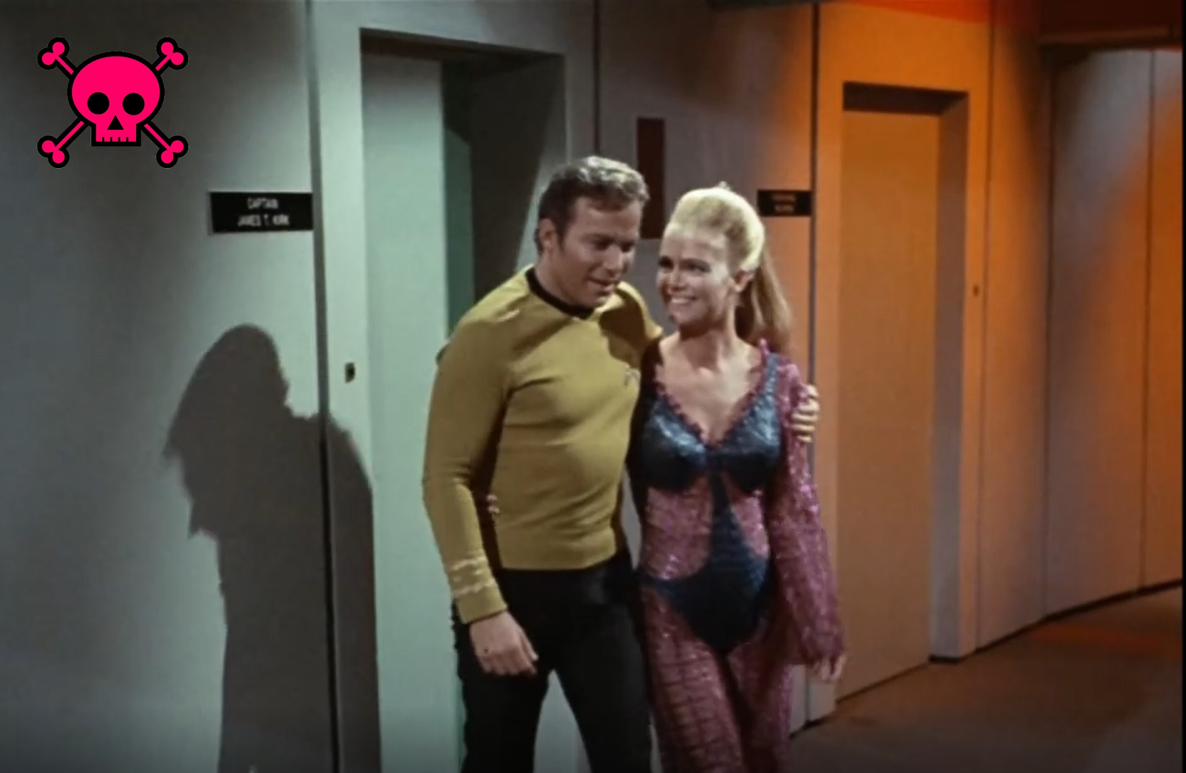 Kirk with his arm around Odonna's shoulders, leading her down a hallway