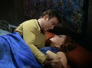 Kirk and a woman in a purple dress wrestling suggestively