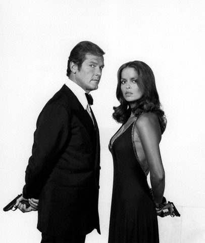 Roger Moore and Barbara Bach pose with guns in a promotional photo for The Spy Who Loved Me